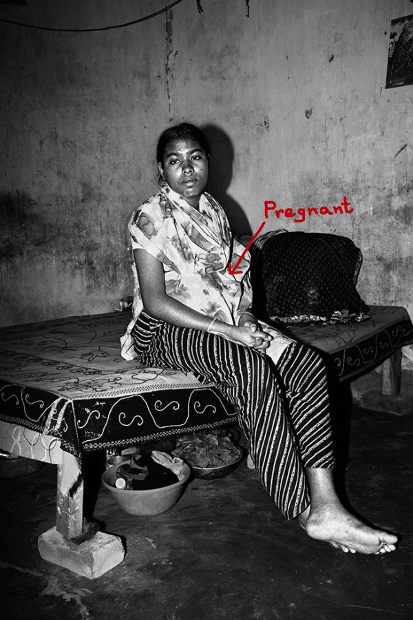 A pregnant woman, who was laid off rather than given maternity leave, sits on her bed in Dhaka. “I was forced to hide in the toilet for two days during the buyer’s visit,” she said. (Gazi Nafis Ahmed)