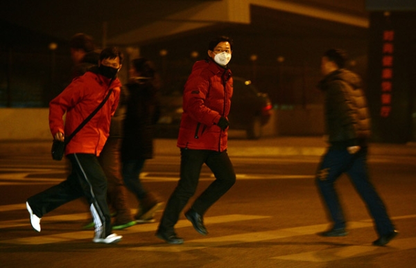 Commuters cross a Beijing street in heavy air pollution, January 30, 2013. On this day, when PM2.5 readings reached a high of 315, according to measurements taken by the U.S. Department of State, Beijing officials urged people to stay indoors. (Mark Ralston/AFP/Getty Images)