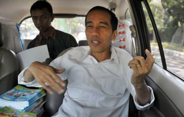 Jakarta governor Joko Widodo, an avowed rock fan, tries some air guitar while traveling by van to a site inspection in Jakarta on Aug. 22, 2013. The charismatic governor is predicted to make a run for Indonesia's presidency in 2014. (Bay Ismoyo/AFP/Getty Images) 