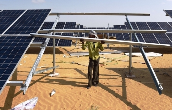 In this photograph taken on August 23, 2015, an Indian engineer fixes a solar panel into position at the under construction Roha Dyechem solar plant at Bhadla some 225 kms north of Jodhpur in the western Indian state of Rajasthan. (Money Sharma/Getty Images)