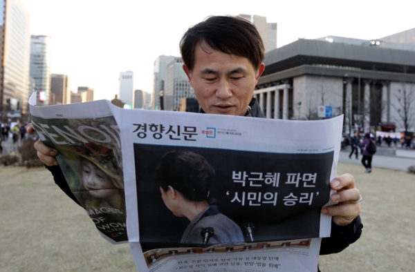  South Korean man reads extra edition newspaper reporting impeached President Park Geun-hye on March 10, 2017 in Seoul, South Korea. (Chung Sung-Jun/Getty Images)