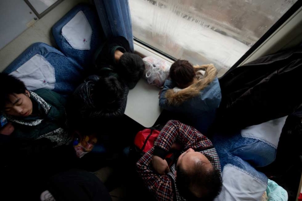 On January 31, 2013, Lunar New Year travellers sleep aboard a train bound for the southwestern Chinese city of Chongqing from Beijing, a journey of 32 hours. (Ed Jones/AFP/Getty Images)