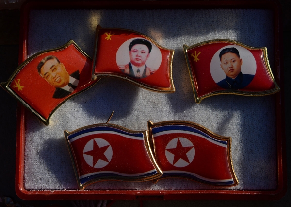 Badges featuring Kim Il Sung, Kim Jong Il, and Kim Jong Un