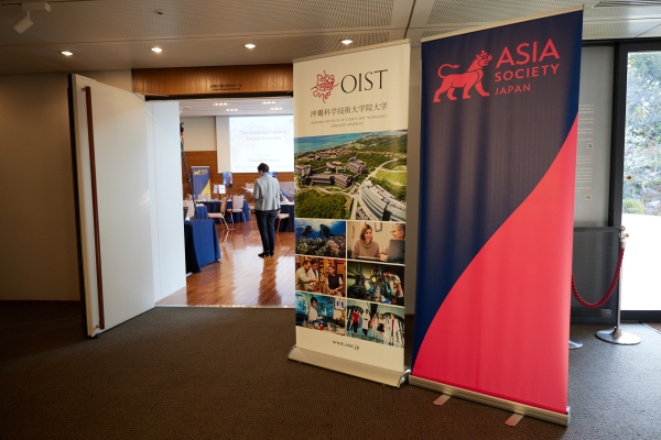 Entrance to the event hall with OIST and Asia Society Japan banners on the right