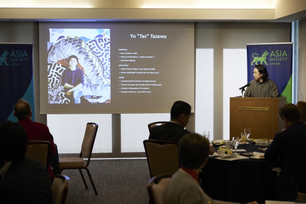 Yu Tazawa giving a presentation showing the slide on screen