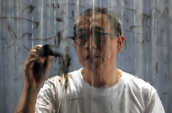 "Writing in the Rain." FX Harsono, 2011. Single-channel video with sound Duration: 6 minutes, 2 seconds.  Image courtesy of the artist and Tyler Rollins Fine Art.