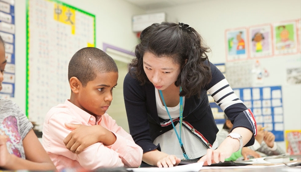 5th grade student going over a lesson with his teacher. (Ann-Marie VanTassell Photography)