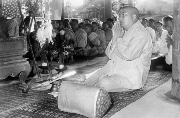 In 1955, King Sihanouk abdicated the throne in favor of his father, wanting to avoid the limitations placed on the title of a constitutional monarch for a more direct role in politics and government. Here he prays with Buddhist monks at "Big Buddha" monastery in Siem Reap, near the Angkor Wat temples. (AFP/GettyImages)  