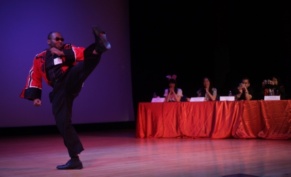 Clif Francisoie strikes a high kick as the judges enthusiastically look on. (David Barreda/Asia Society)
