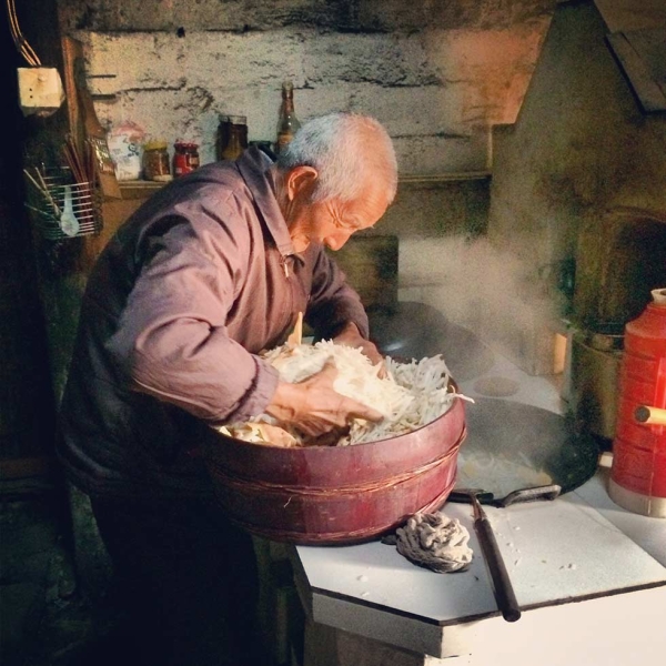 A villager cooking shredded sweet potato and daikon for his pig. As the Spring Festival approaches, households race against time to make their pigs gain more weight before they are to be slaughtered in time for new year’s eve. (Sun Yunfan)

