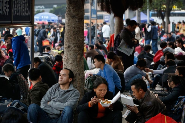 Instead of waiting inside of train and bus stations overflowing with passengers eager to get home, some people decide to pass time outside on January 28, 2014 in Guangzhou, China. (Theodore Kaye/Getty Images)