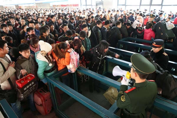 Passengers prepare to board the trains that will eventually take them home for the Spring Festival on January 26, 2014 in Beijing, China. (ChinaFotoPress/Getty Images)