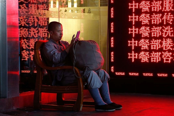 A Buddhist monk waits for his train at the railway station before making the long journey home on January 28, 2014 in Shenzhen, China. (Theodore Kaye/Getty Images)