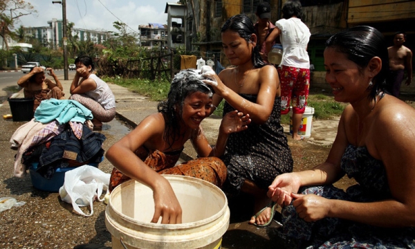 Women use a bucket to cleanse themselves on May 8, 2008 in downtown Yangon. (Chumsak Kanoknan/Getty Images)