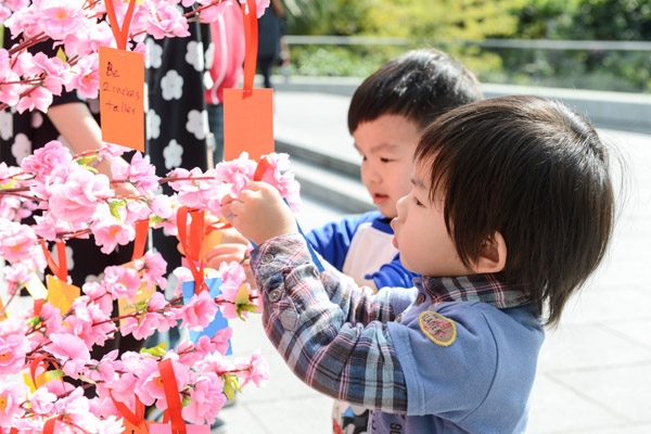 Kids hanging their wishes on the wishing tree 
