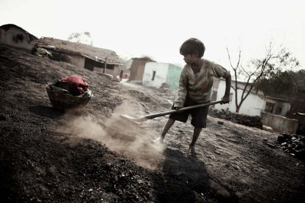 A child collects small fragments of coal. (Erik Messori)