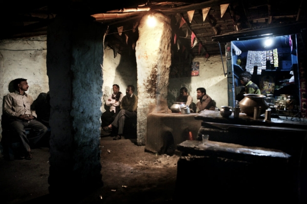 Miners sip on chai after work in the only public place in the village. (Erik Messori)