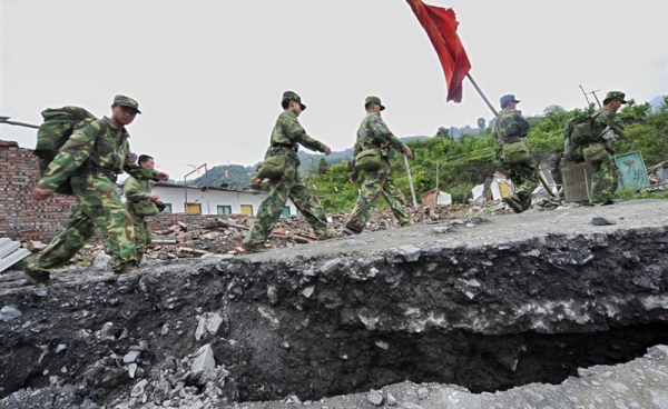 Chinese soldiers walk along a collapsed section of a mountain road in Wenchuan County as they make their way to the earthquake epicenter of Wenchuan City on May 14, 2008. (Teh Eng Koon/AFP/Getty Images)