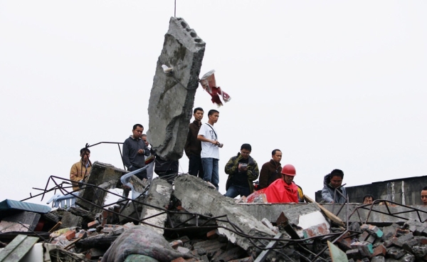 Residents watch soldiers rescue people from a ruined building in Sichuan province&apos;s Dujangyan City on May 13, 2008. (Guang Niu/Getty Images)