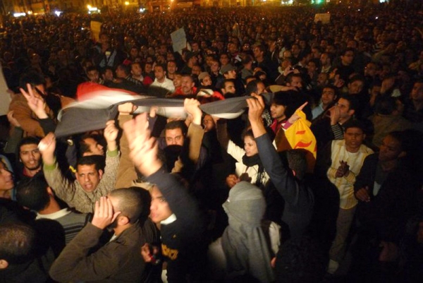 Egyptian protestors hold their national flag during demonstration in Cairo on January 25, 2011 demanding the ouster of President Hosni Mubarak (Al Jazeera).
