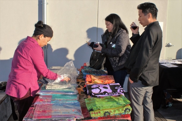 Dolma Chuteng displays Tibetan textiles from Laxmi Textiles and Fabrics to attendees (Stesha Marcon Asia Society).