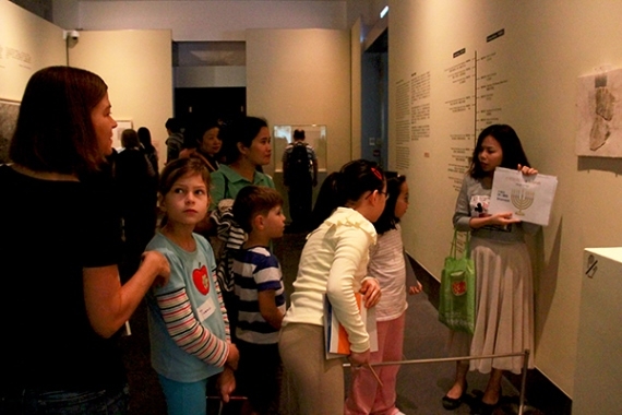 Ms. Sally Yeung explained to the children the patterns on the decorated stone fragment during the gallery tour.
