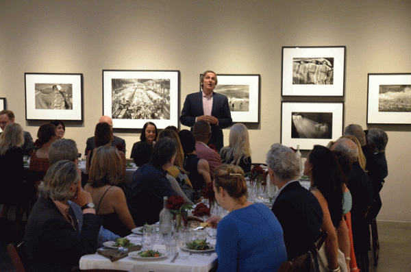 Asia Society Southern California Board Member Brian Treiger welcomes guests to the June 4 dinner with Sebastiao Salgado at the Peter Fetterman Gallery. Behind Brian to the left is Salgado’s famous image of Mumbai’s Churchgate Train Station.
 