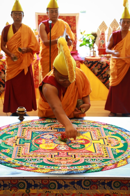 The monks sweep up the mandala’s colored sands during the closing ceremony (Jessica Ngo)