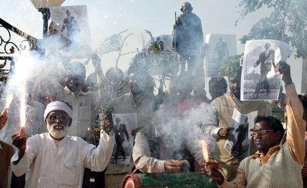 Indian tribal organization activists celebrate in front of a statue of Mahatma Gandhi in Ranchi, India on November 5, 2008. (STR/AFP/GettyImages)