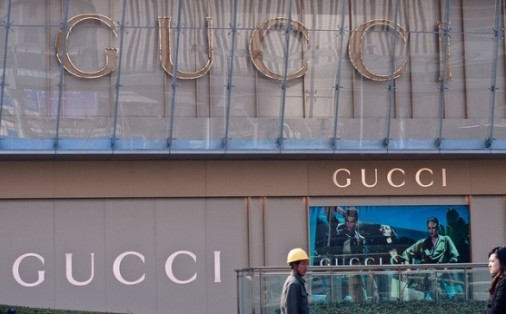 Migrant worker in front of a Gucci store. (Matthew Stinson/Flickr)