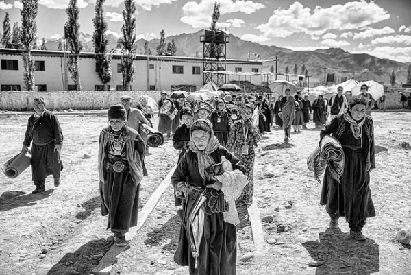 A large group of people trek carrying personal belongings through Ladakh, India on July 10, 2014. (Christopher Michel/ Flickr)