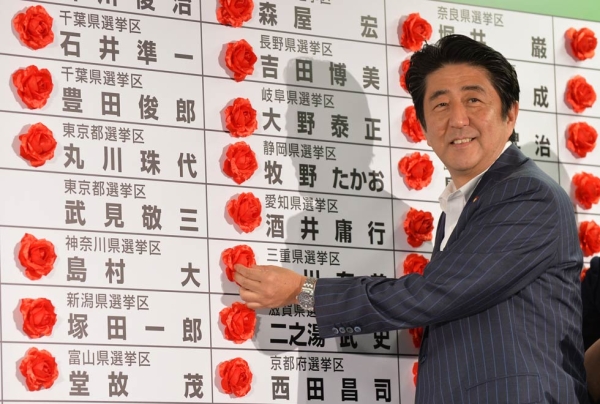 Japanese Prime Minister and President of the Liberal Democratic Party (LDP) Shinzo Abe claims a decisive victory on July 21, 2013. His economic policies, dubbed "Abenomics," made headlines as Japan's unemployment lowered in 2013. (Kazuhiro Nogi/AFP/Getty Images)