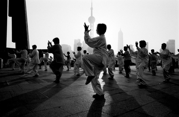 A group of people perform Tai Chi in the morning on the banks of the Huang Pu River in Shanghai. (Ryan Pyle)
