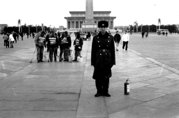 A solider stands next to a fire extinguisher in Tiananmen Square in Beijing. The irony is that everything there is made of stone. (Ryan Pyle)