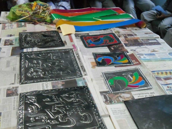 Etched metal plates laid out to be finished in brightly colored reflective stickers. (Pakistan Youth Alliance)