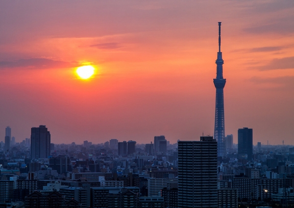 An evening sun reaches toward the horizon of Tokyo's skyline in Japan, photographed on May 26, 2012. (arcreyes [-ratamahatta-]/Flickr)