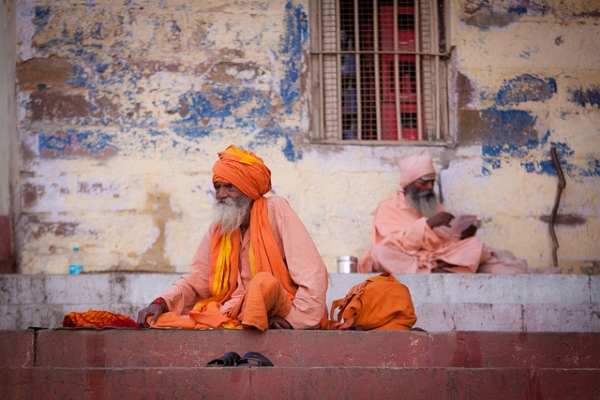 Two venerable Hindu men almost seem to be mirror images of each other on the steps of a building in Varanasi, India on March 17, 2012. ([ changó ]/Flickr)