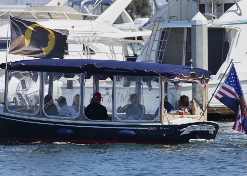 A boat flies a flag bearing an image of Donald Trump, during a demonstration of support for the then former president and presidential candidate in Huntington Harbor, Huntington Beach, July 27, 2024.