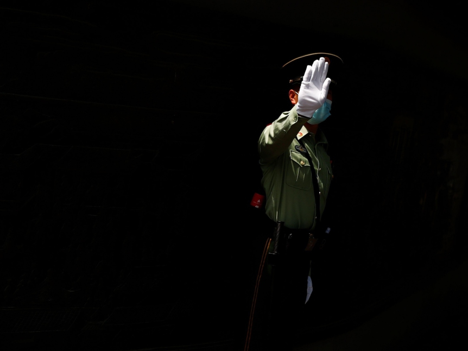 A policeman in Beijing gestures to a photographer