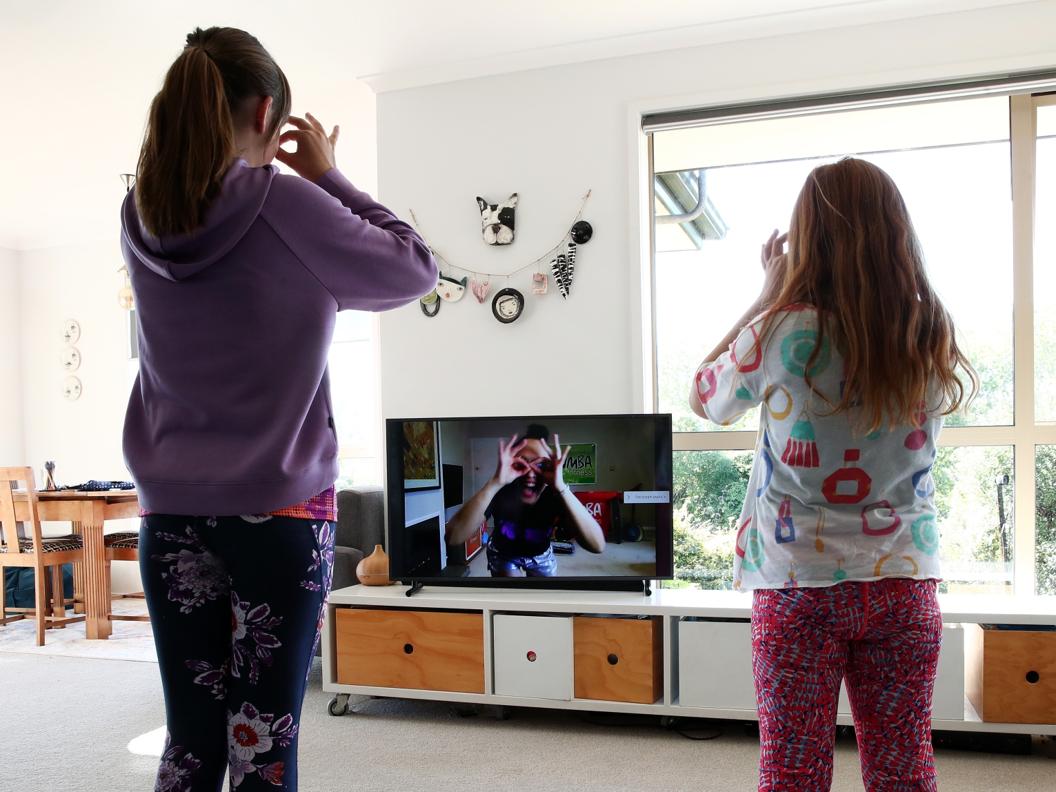 Two sisters follow a Zumba lesson online in Auckland, New Zealand, during the COVID-19 pandemic.