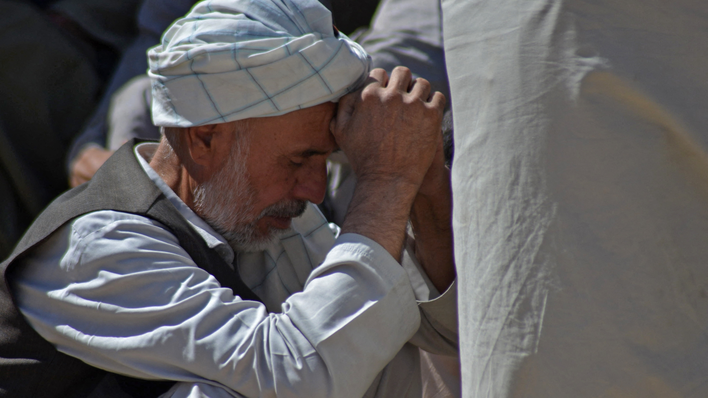 A man mourns the death of his relative at a graveyard in Kandahar on October 16, 2021.